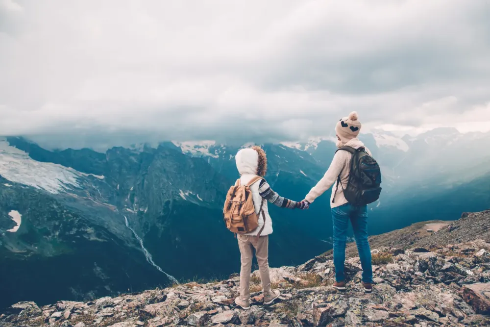 Two kids holding hands on a mountain overlook